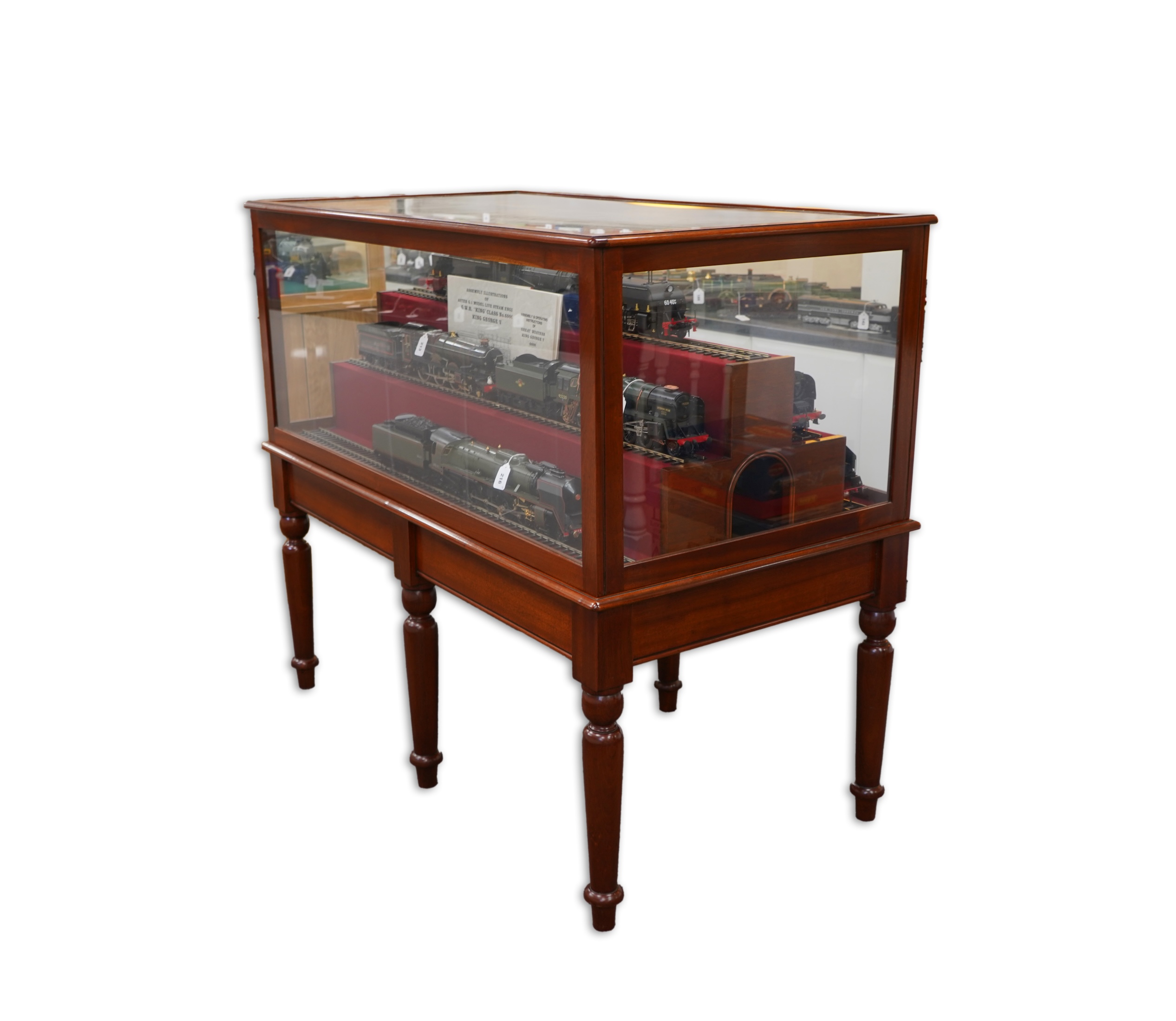 A substantial tiered display cabinet in a mahogany-tinted hardwood, with a lift off glazed cover, intended for Gauge One model railway rolling stock, currently fitted with five lengths of 45mm display railway track, dime